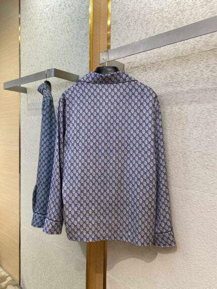 Camicia blu con fantasia geometrica, stile casual e semi-formale, esposta su portariviste minimalista.