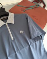 Maglietta polo blu con colletto grigio e borsa arancione elegante per shopping di stile.