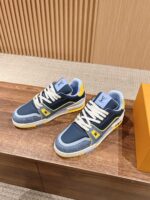Sneakers sportive blu navy, giallo e grigio su tavolo in legno, stile urbano e moderno.