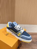 Sneaker moderna blu e gialla su scatola arancione, elegante e di lusso.
