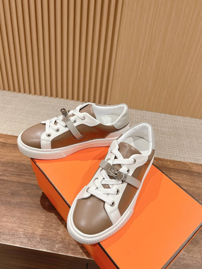 Sneakers in bianco e marrone su scatola arancione, stile casual e dettagli di qualità.