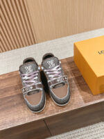 Sneakers moderne marroni e grigie con lacci rosa, scatola arancione, stile elegante e raffinato.
