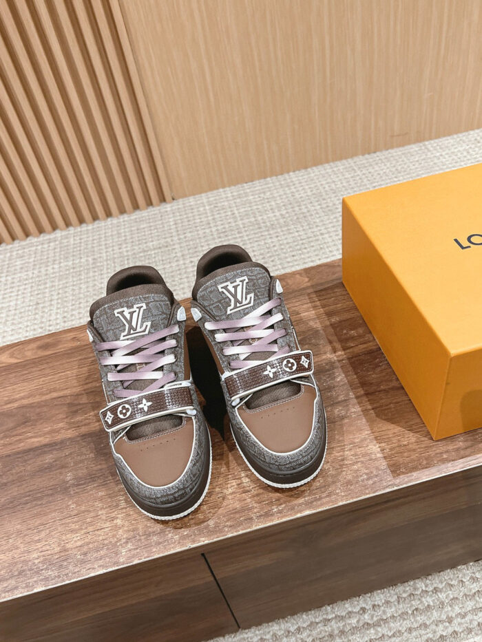 Sneakers moderne marroni e grigie con lacci rosa, scatola arancione, stile elegante e raffinato.