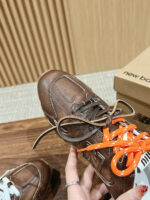 Sneaker in pelle marrone con lacci arancioni, stile moderno, brand New Balance, footwear di qualità.