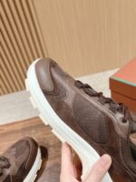 Sneaker marrone moderno con suola bianca, design elegante, comfort e stile urbano.