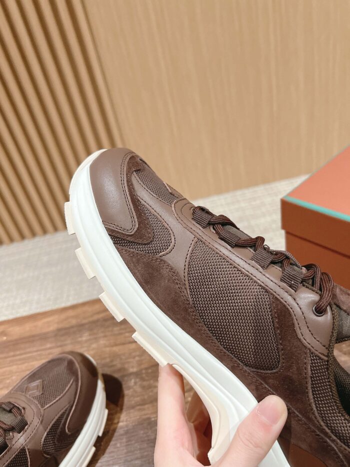 Sneaker marrone moderno con suola bianca, design elegante, comfort e stile urbano.