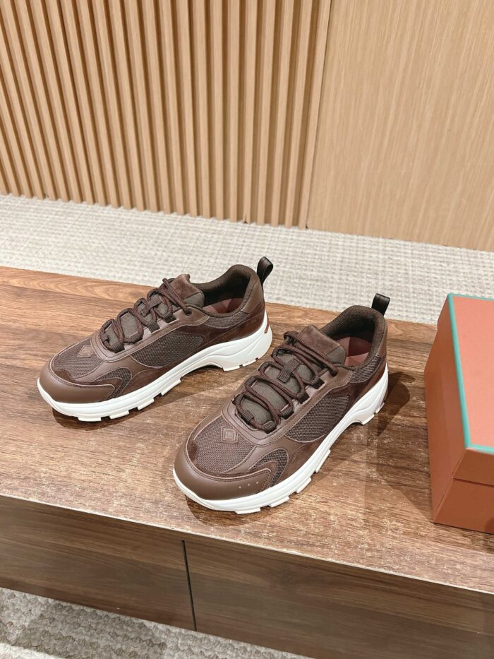 Scarpe sneakers marroni moderne con suola bianca su superficie di legno, eleganti e di tendenza.