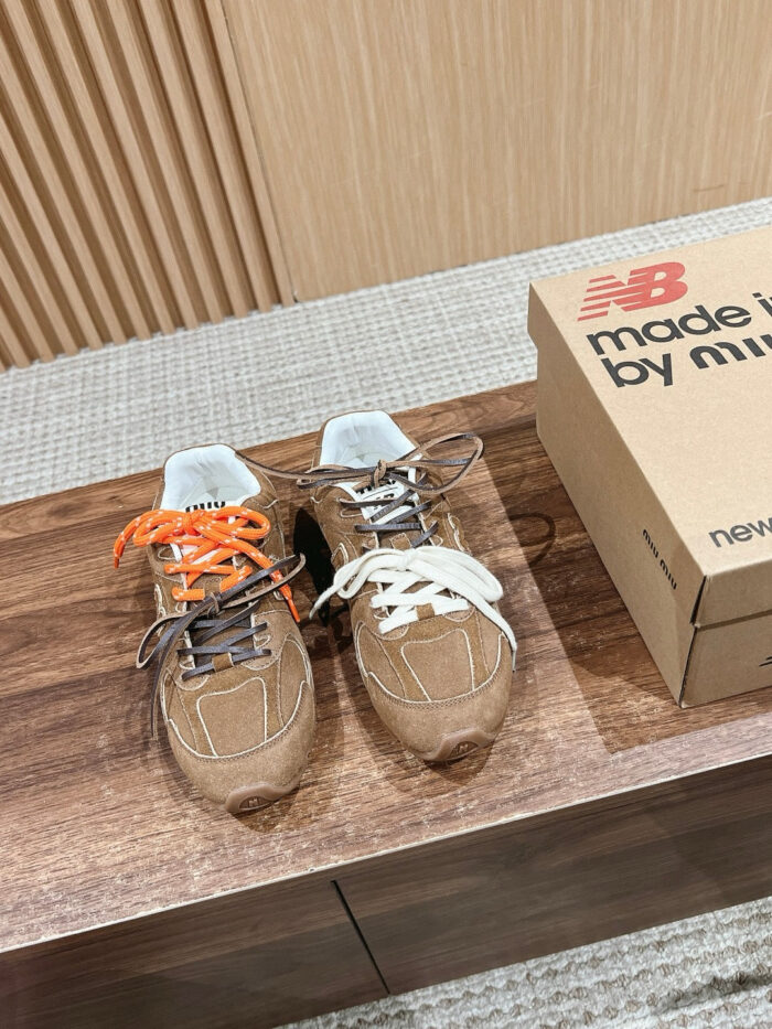 Sneakers New Balance con lacci colorati su legno, stile moderno e comfort elegante.