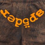 Pantaloni jogger marroni con grafica arancione, stile streetwear, comfort e look dinamico.