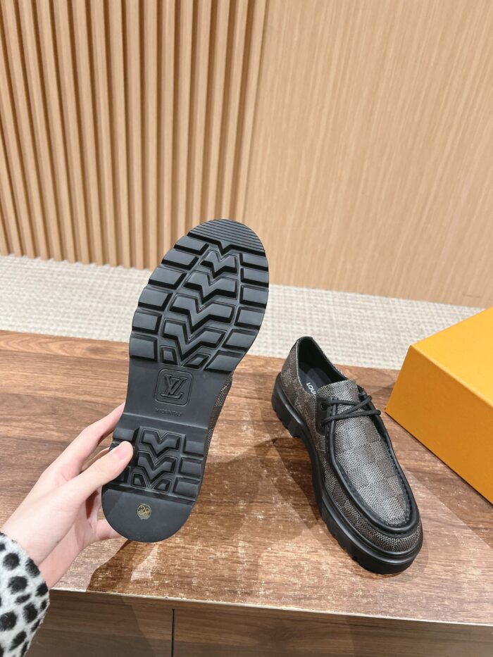 Scarpe uomo eleganti con suola antiscivolo e packaging arancione su superficie in legno