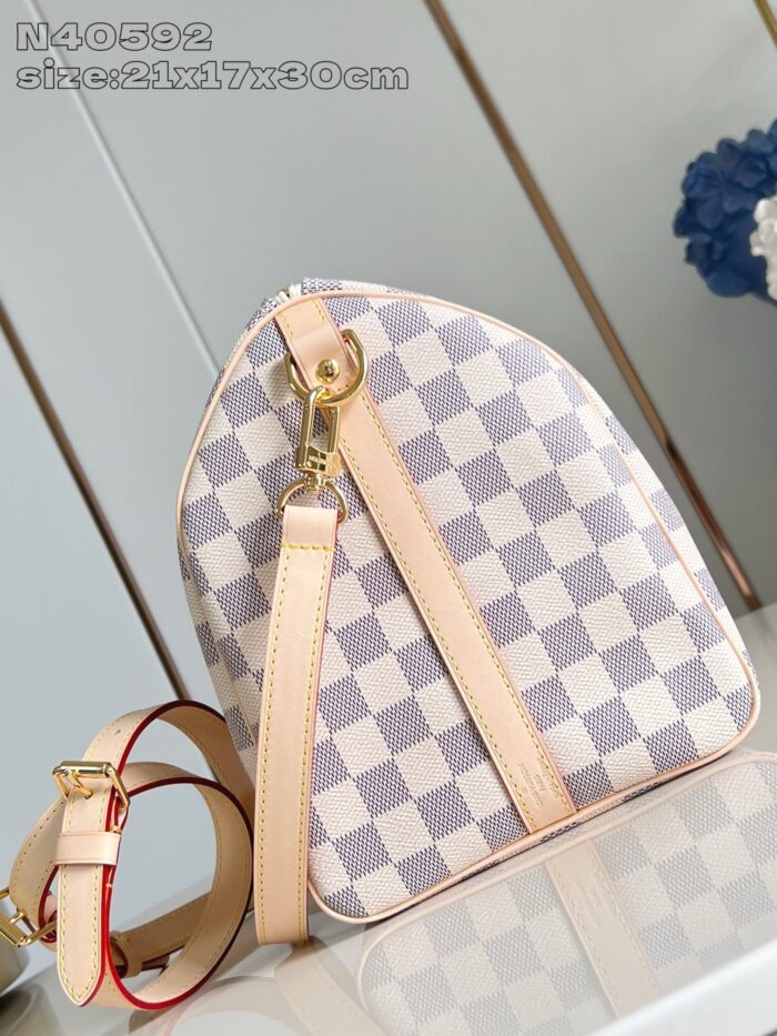 Borsa a forma triangolare con stampa checkered pastello, cinturino regolabile e dettagli in oro.