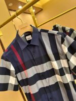 Camicia a quadri moderna con dettagli colorati, maniche corte, stile casual chic, negozio elegante.