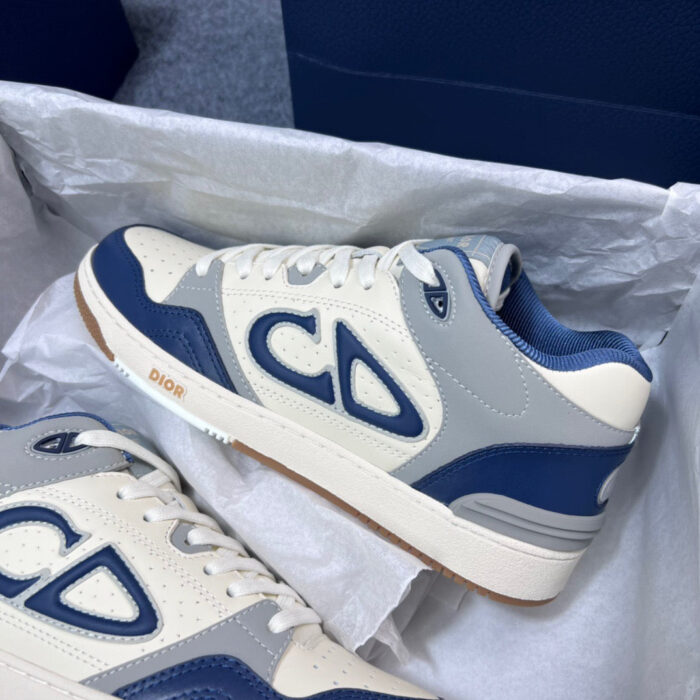 Sneakers eleganti crema e navy con logo CD, suola in gomma vintage, perfette per uno stile casual raffinato.