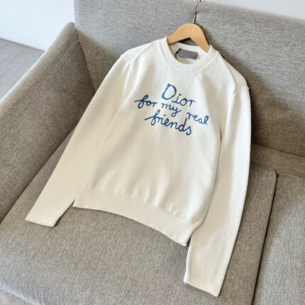 Felpa bianca con ricamo blu Dior for my real friends su poltrona moderna e confortevole.
