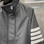 Giacca sportiva grigia moderna con strisce bianche e zip frontale, stile minimalista e versatile.