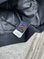Giacca nera elegante con etichetta raffinata e dettagli di alta qualità in interior design.