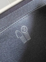 Borsa decorata in denim con logo ricamato e chiusura a zip, stile minimalista e moderno.