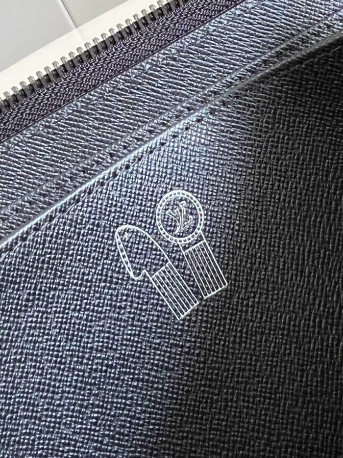 Borsa decorata in denim con logo ricamato e chiusura a zip, stile minimalista e moderno.