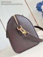 Borsetta in pelle marrone con zip oro, formato rotondo e tracolla versatile per ogni occasione.