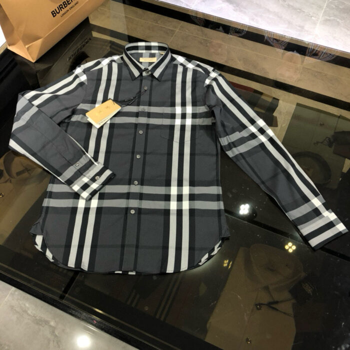 Camicia scozzese grigia di lusso Burberry, stile moderno e raffinato su superficie riflettente.