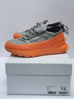 Sneakers grigie moderne con suola arancione, comfort, stile e supporto per ogni attività quotidiana.