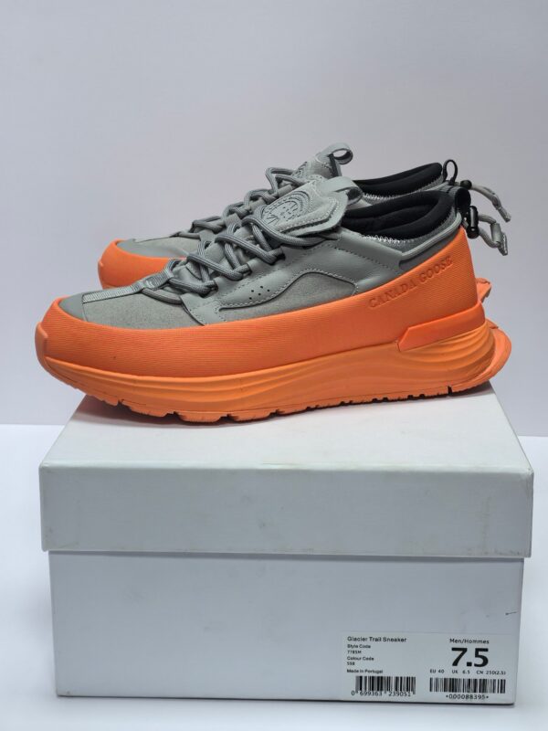 Sneakers grigie moderne con suola arancione, comfort, stile e supporto per ogni attività quotidiana.