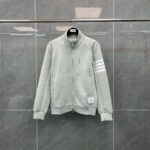 Giacchetto grigio sportivo con zip, strisce sulle maniche e stile moderno e comodo.