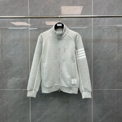 Giacchetto grigio sportivo con zip, strisce sulle maniche e stile moderno e comodo.