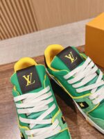 Sneakers di lusso verdi con dettagli gialli, logo LV in oro e stile elegante e casual.