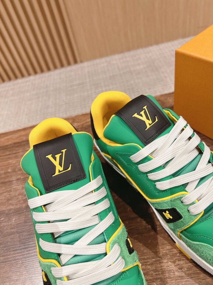 Sneakers di lusso verdi con dettagli gialli, logo LV in oro e stile elegante e casual.