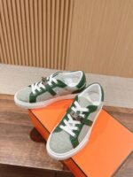 Sneakers casual grigi e verdi su scatola arancione, stile moderno e comfort urbano.