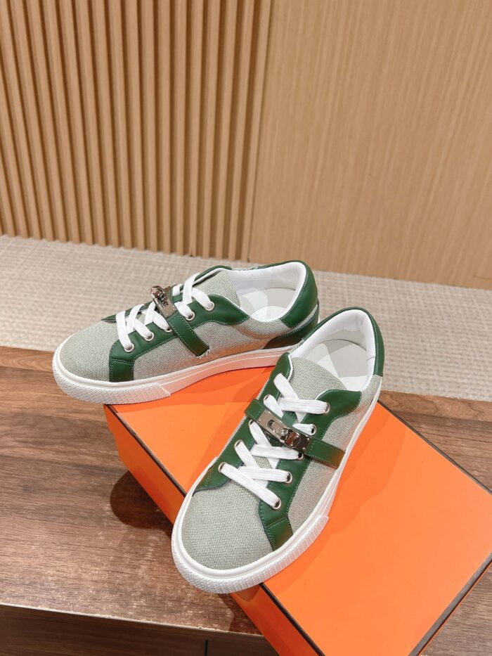 Sneakers casual grigi e verdi su scatola arancione, stile moderno e comfort urbano.