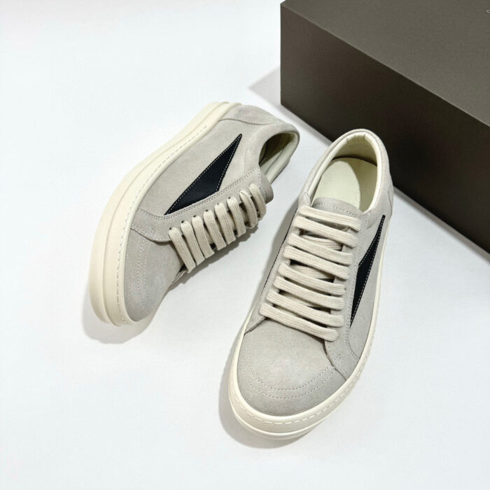 Sneakers in suede grigio con dettaglio blu, suola bianca, stile casual e moderno.