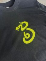 T-Shirt nero con logo neon snake in movimento, stile moderno e grafico per stile audace.