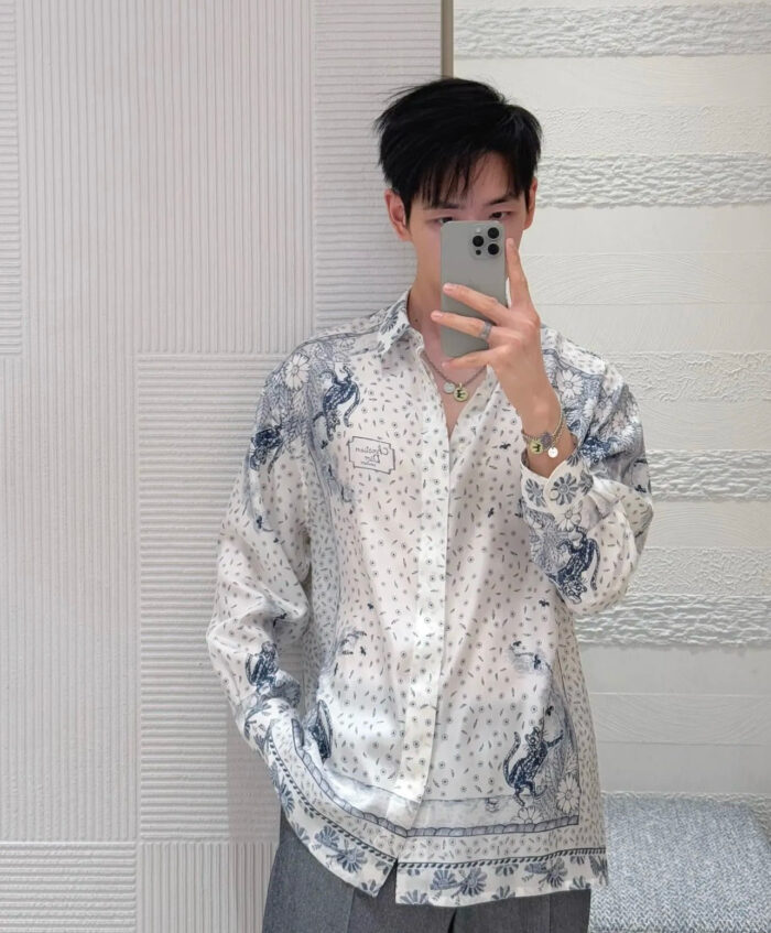 Uomo giovane con camicia moderna a motivi, selfie in casa, stile fashion e casual.