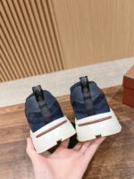 Sneakers navy e bianco con suola marrone, tirante nero, stile sportivo e comfort quotidiano.