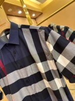 Camicia check navy e grigia con dettaglio rosso, stile moderno e vestibilità elegante.