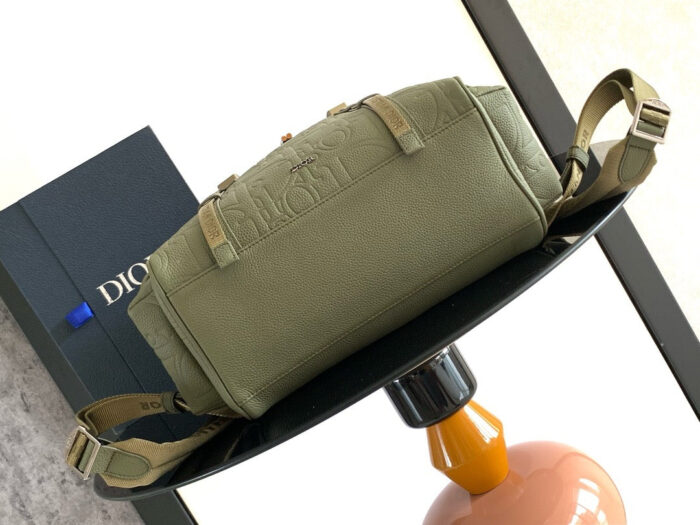 Borsa verde oliva di lusso su tavolo elegante, con scatola Dior, stile e qualità raffinata.