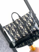 Borsa elegante in beige e navy con design intrecciato, tracolla regolabile e stile moderno.