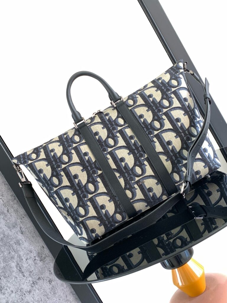 Borsa elegante in beige e navy con design intrecciato, tracolla regolabile e stile moderno.