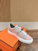 Sneaker rosa e grigia su scatola di lusso arancione, stile moderno e sofisticato.