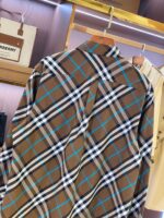 Camicia a quadri marrone, blu e bianco su appendiabiti, stile casual e moda maschile.
