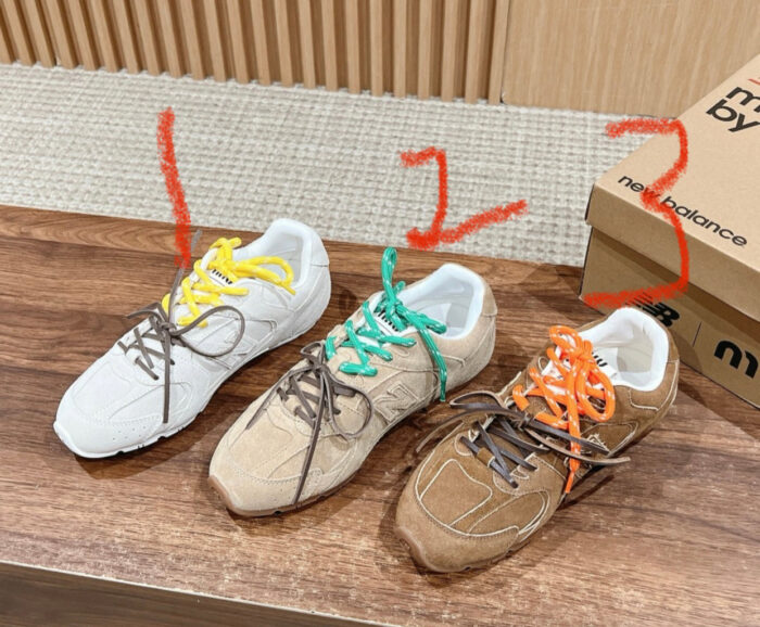 Sneakers New Balance diverse in colori e stili su tavolo in ambiente moderno.