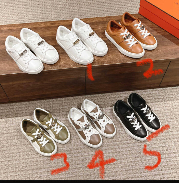 Scarpe da sneakers alla moda su banco di legno con scatola arancione e sfondo chiaro.