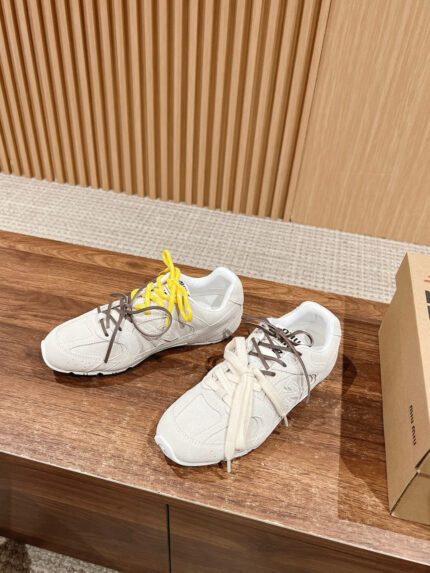 Scarpe sportive moderne con lacci colorati su superficie di legno lucido.
