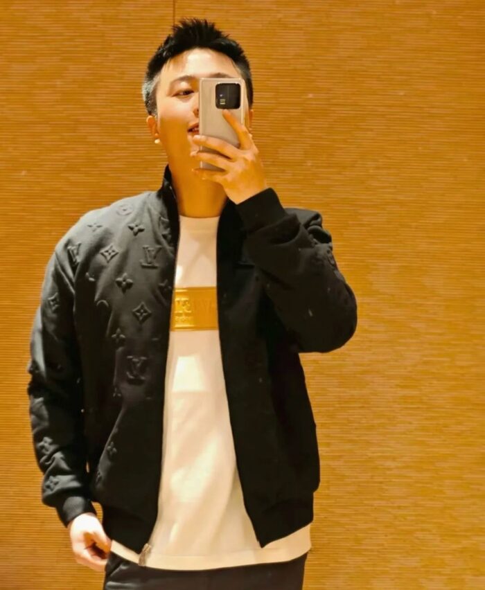 Ragazzo in stile streetwear scatta un selfie davanti allo specchio con abbigliamento trendy e moderno.
