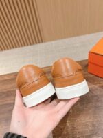 Scarpe eleganti in pelle tan con suole bianche, stile moderno e comfort.