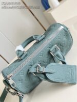Borsa cilindrica in teal con dettagli metallici, elegante e versatile per ogni occasione.