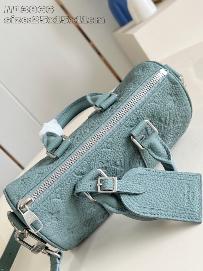 Borsa cilindrica in teal con dettagli metallici, elegante e versatile per ogni occasione.
