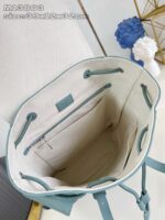 Borsa in teal con interno spazioso, chiusura a corda e dettagli eleganti, ideale per ogni occasione.